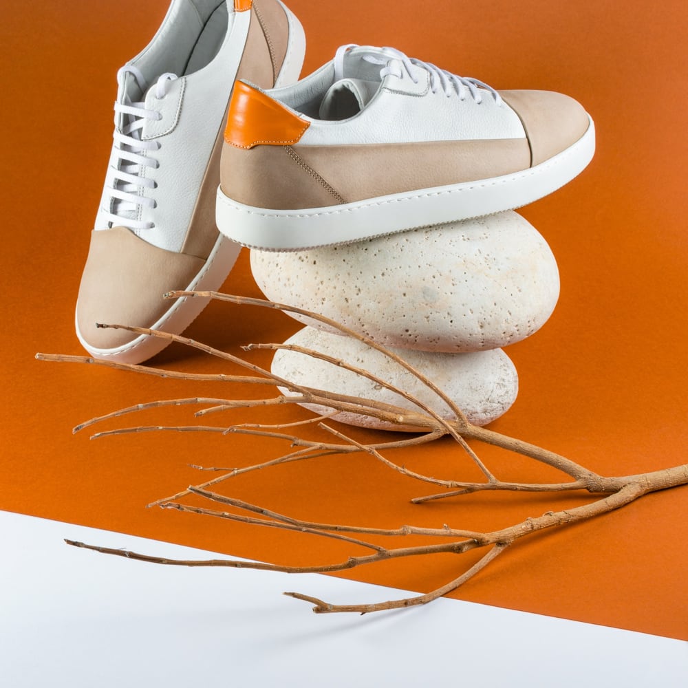 sneakers on three rocks superposed and behind a sticker of tree
